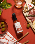Small batch BBQ Smoked Maple Hot Sauce from Ark Pepper Co styled in a rustic kitchen setting