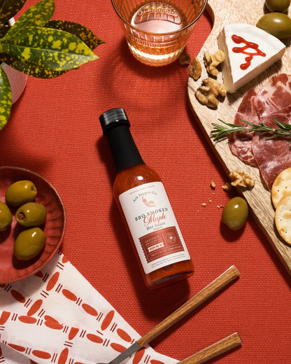 Small batch BBQ Smoked Maple Hot Sauce from Ark Pepper Co styled in a rustic kitchen setting