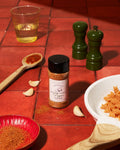 Small batch Roasted Garlic Pepper seasoning from Ark Pepper Co being sprinkled over food